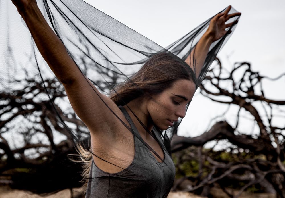 Woman posing on twigs of dry trees