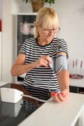 Mature woman measuring blood pressure