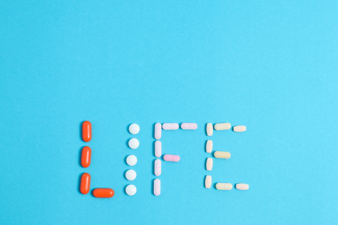 Multiple pills making the word "LIFE" with space for text