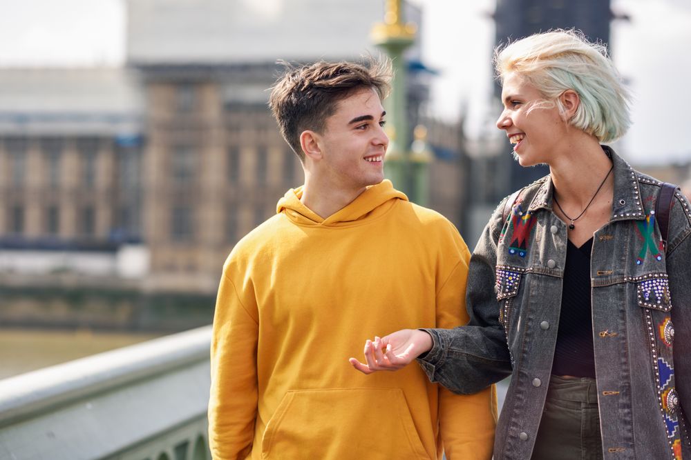 Male and female friend walking on Westminster bridge