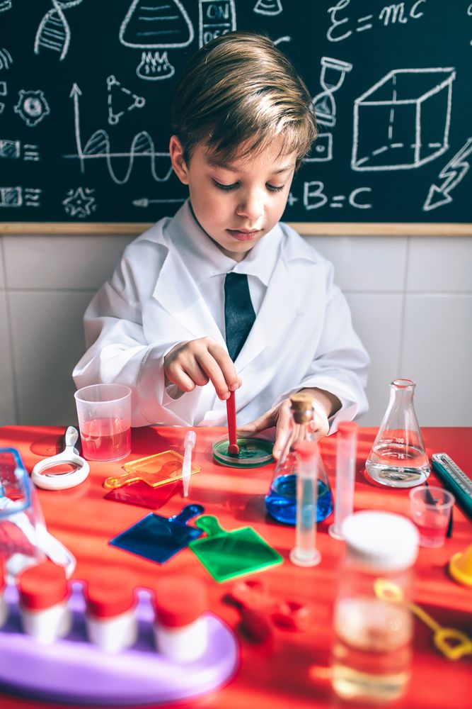 Kid playing chemist with colorful liquids