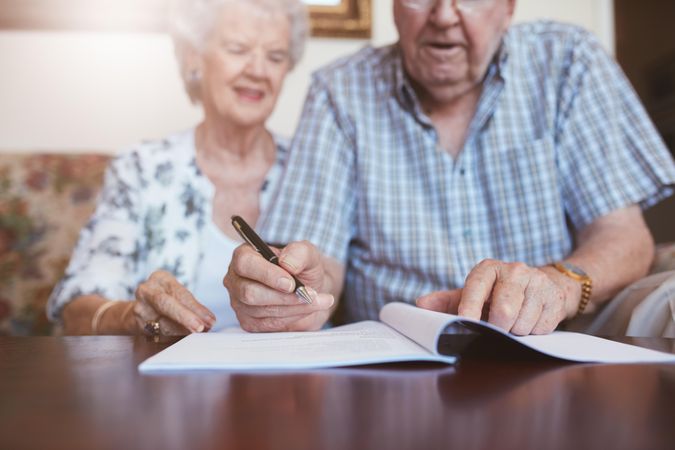 Older couple signing will documents