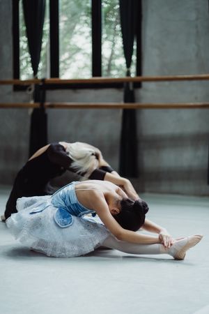 Woman and girl in blue tutu stretching