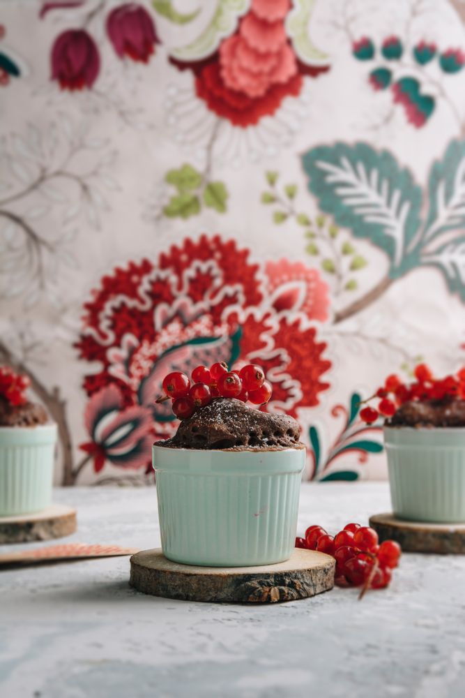 Three Chocolate cakes in the cup with currants and sugar glass.