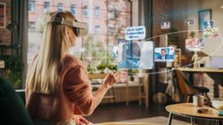 Woman Sitting in Loft Living Room at Home, Using Virtual Reality Headset with Controllers to Check Social Media Streaming App