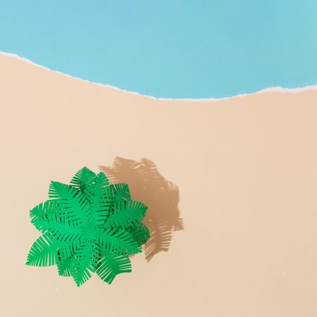 Tropical palm tree on sandy beach made of paper