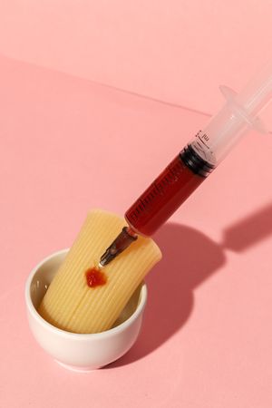 Stuffed pasta with red sauce in syringe