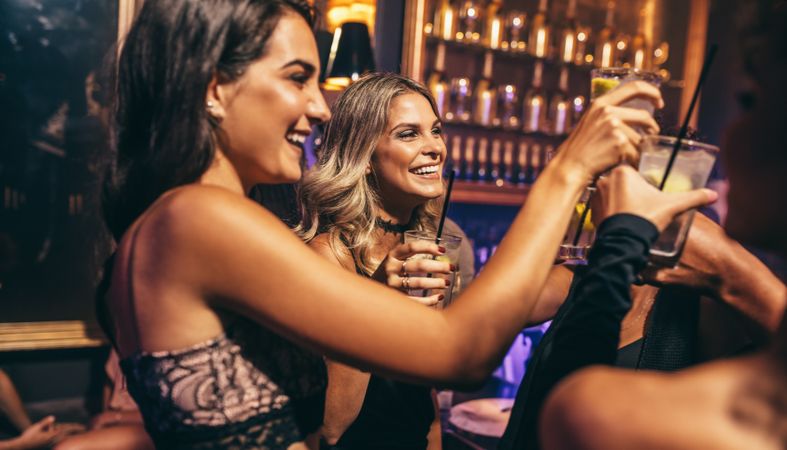 Friends toasting cocktails in nightclub