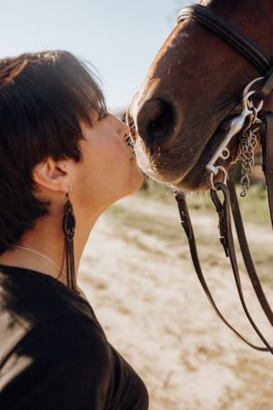 Woman kissing horse on ranch