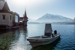 Boat at pier on lake in mountain landscape