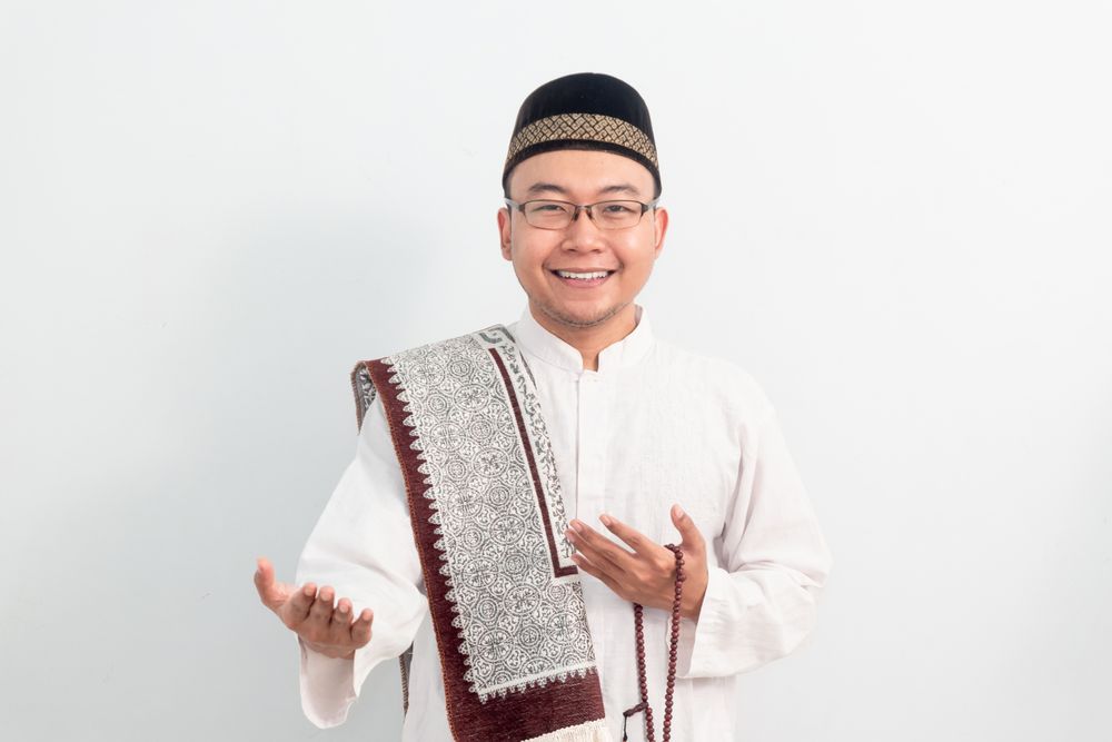 Asian Muslim man smiling doing greeting pose during Ramadan