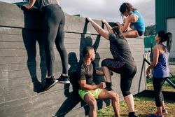Participants in obstacle course climbing wall