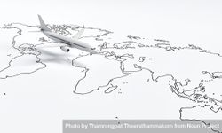 Wide shot of plane model going over drawn map travel plane 4AQrY4