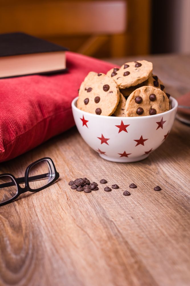 Chocolate chip cookies and milk on wood background