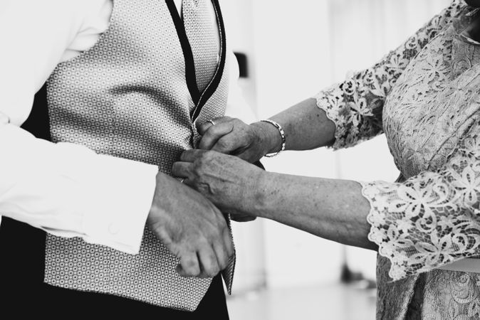 Woman buttoning up man waistcoat