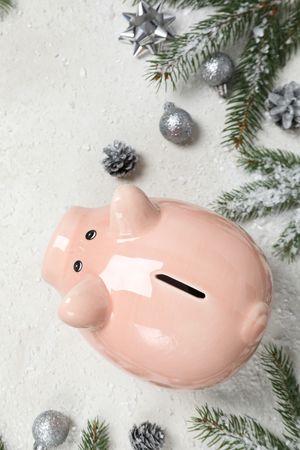 Piggy bank, fir branches and Christmas decorations on cream background, top view