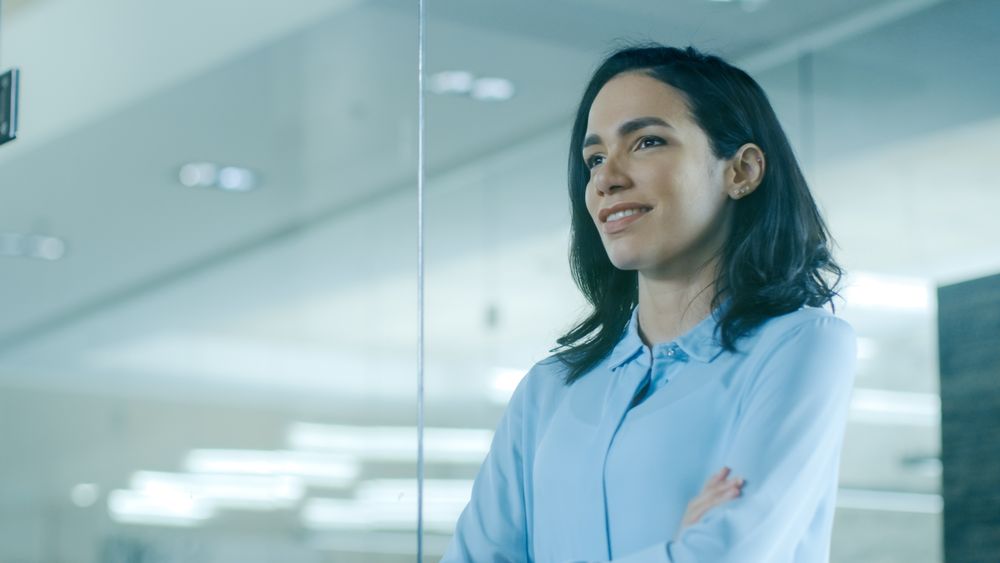 Female CEO in Her Office Looks out of the Window.