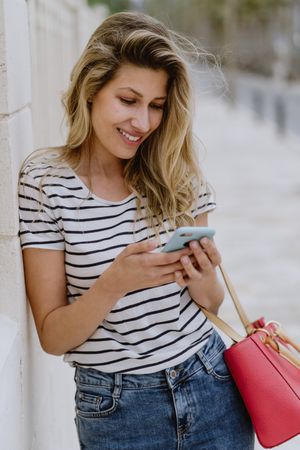 Woman using phone on city street