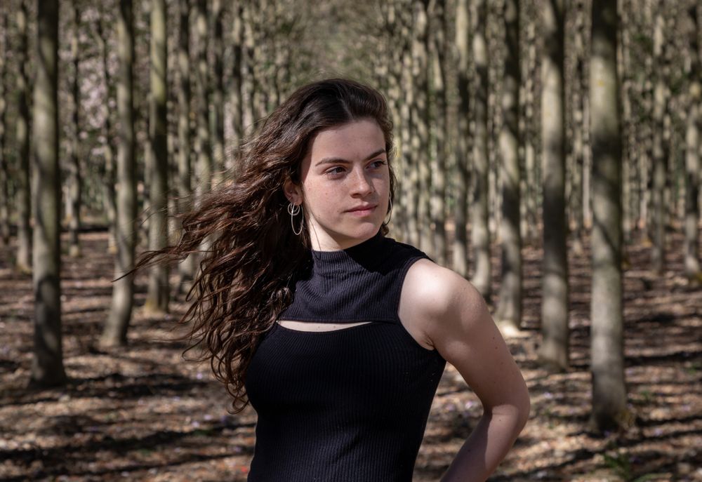 Sporty teenage girl standing in forest