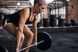 Blonde woman deadlifting in gym