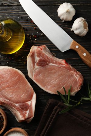 Composition with raw meat for steak and ingredients on wooden background
