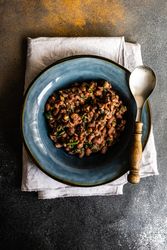 Top view of navy bowl full of hearty bean dish