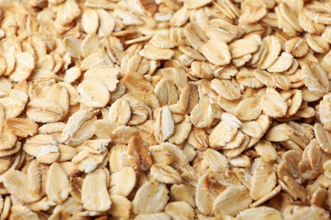 Oatmeal flakes texture on whole background, close up