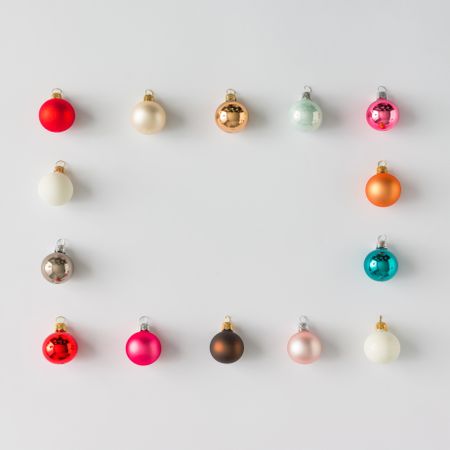 Border of colorful Christmas bauble decorations on light background