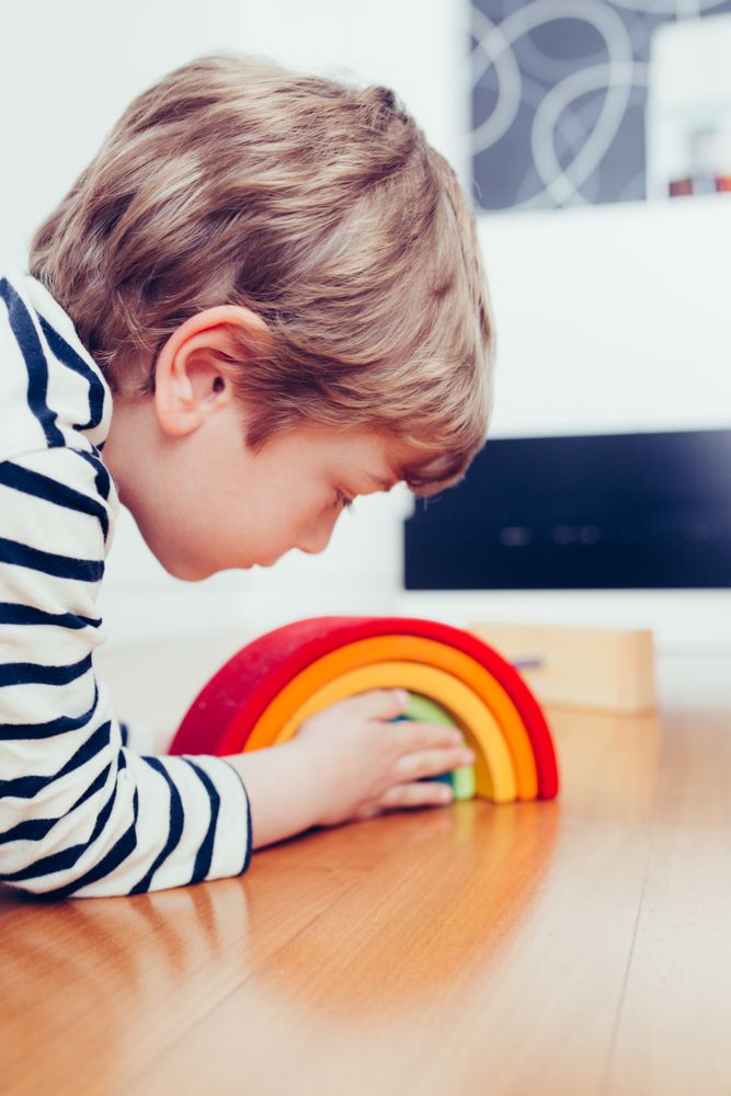 Boy playing with wooden construction pieces