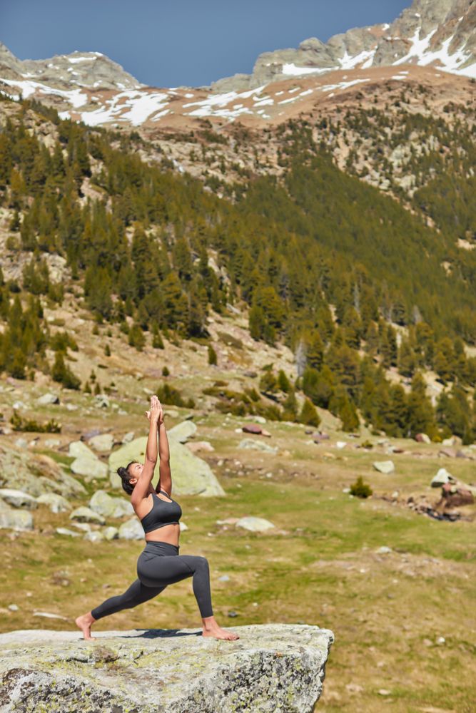Young woman in morning light doing yoga in the mountains
