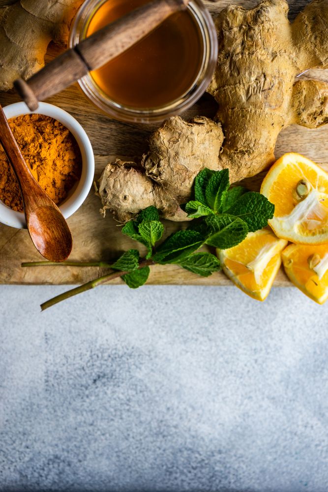 Top view of raw ginger, turmeric & honey on board