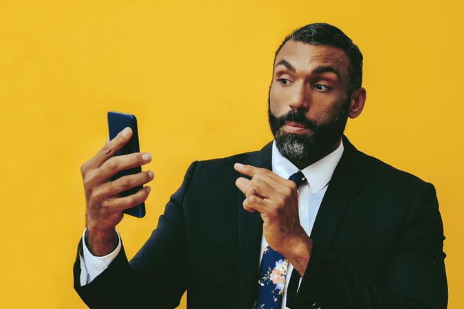 Serious Black businessman having a video call on a smartphone screen