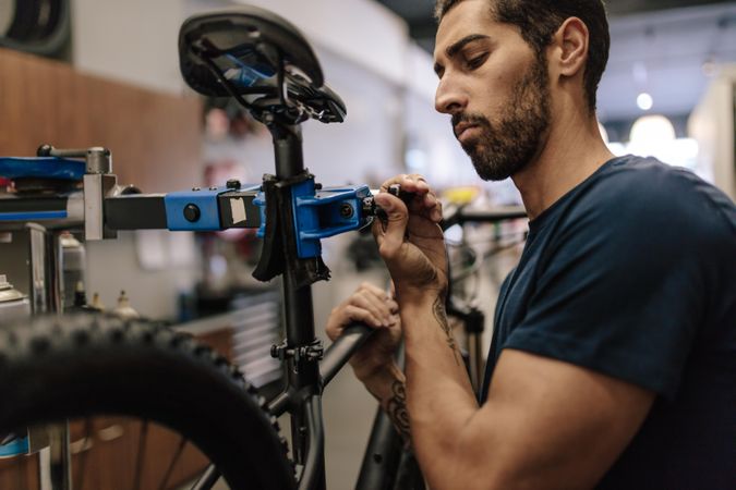 Worker adjusting the seat of a bicycle in a shop