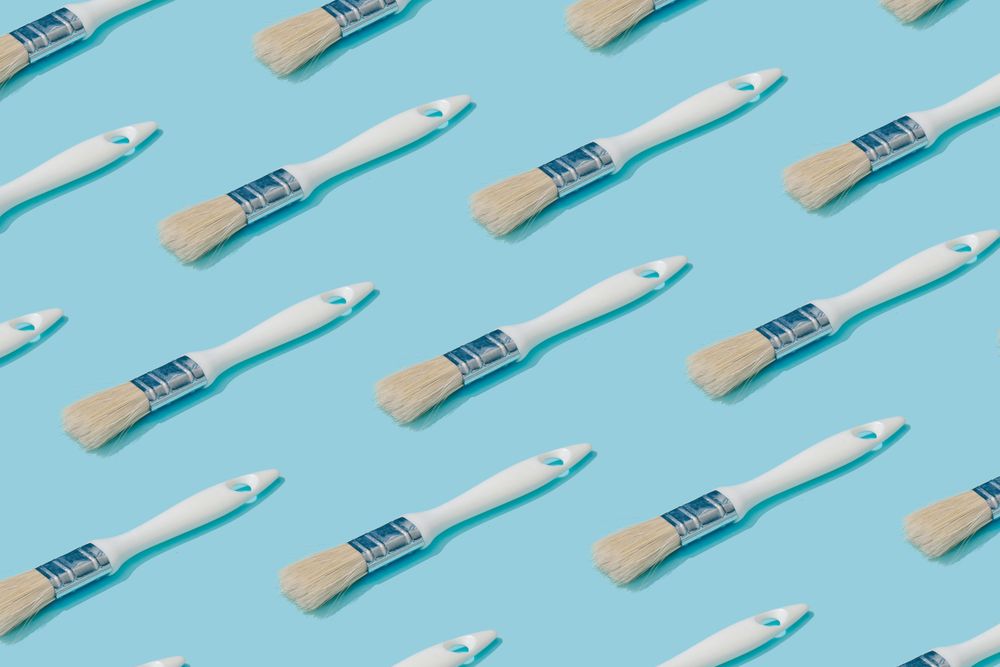 Pattern composition of light  paint brushes on pastel blue background