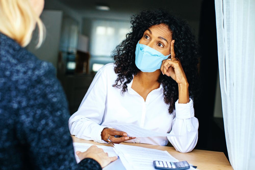 Two colleagues discussing documents while wearing facemask