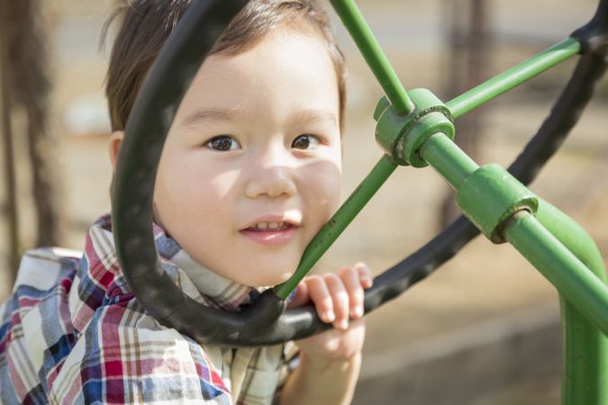 Biracial Young Boy Playing on Tractor Outside