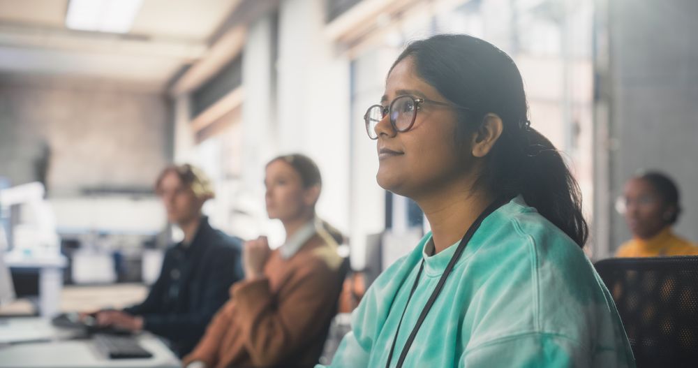 Indian Woman Listening to Teacher, Using Computer to Apply Her Knowledge to Acquire New IT Skills in Class