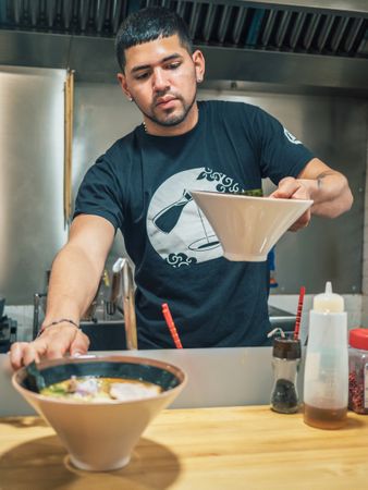 Male serving bowls with soup in restaurant