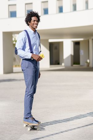 Man smiling while riding skateboard outside