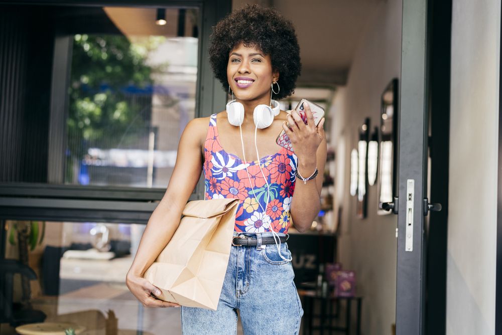 Woman leaving cafe with brown bag
