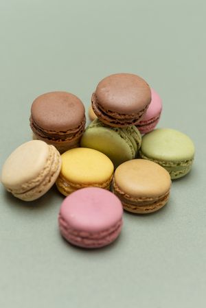 Looking down at macaroons scattered on a green table