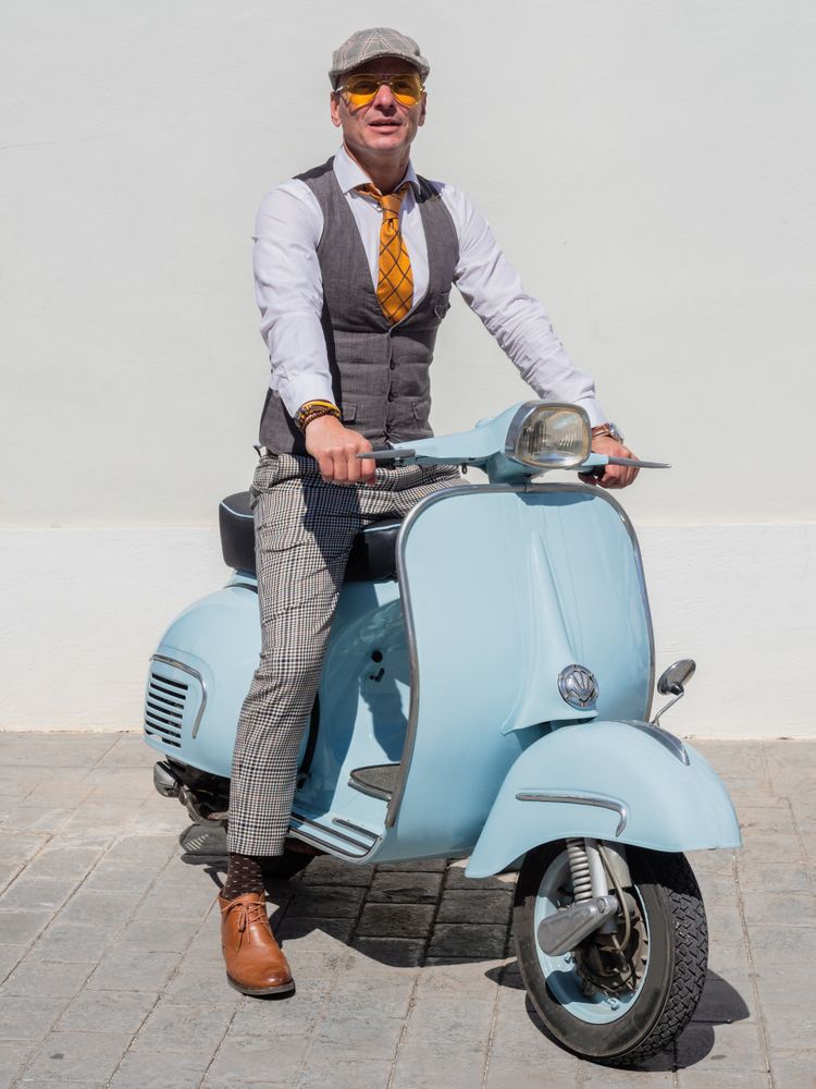 Trendy man sitting on vintage scooter