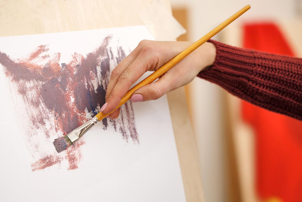 Hand of artist beginning to paint a picture
