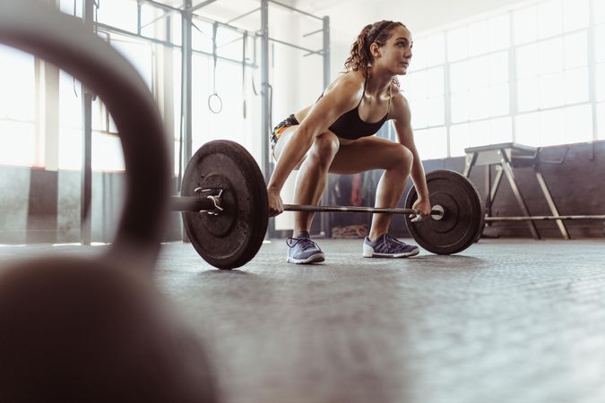 Young woman lifting a barbell at the gym