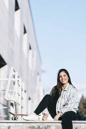 Young woman posing with skateboard