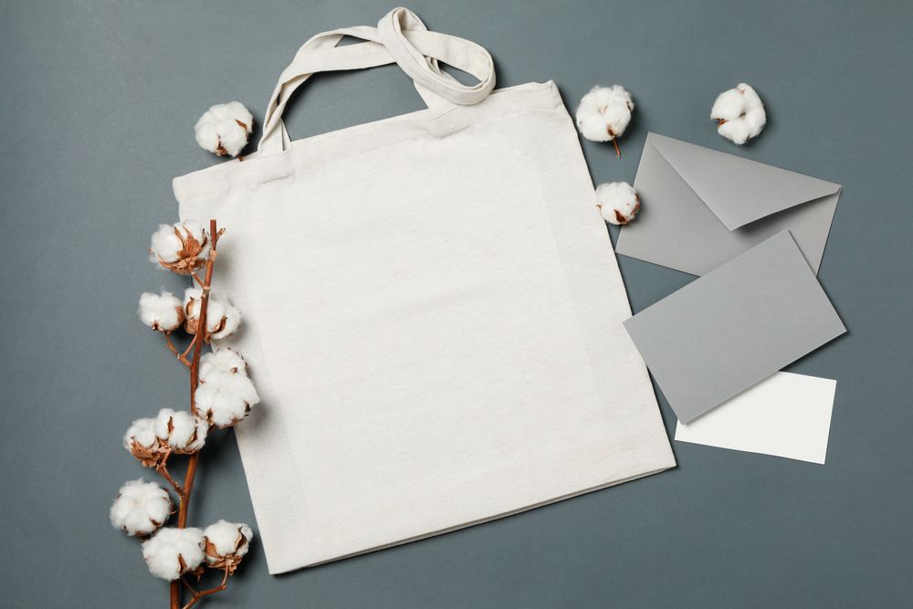 Cotton, bag and envelope on light dark background, space for text