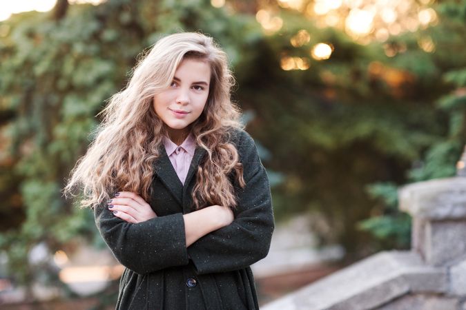 Teenage girl in dark coat standing outdoor