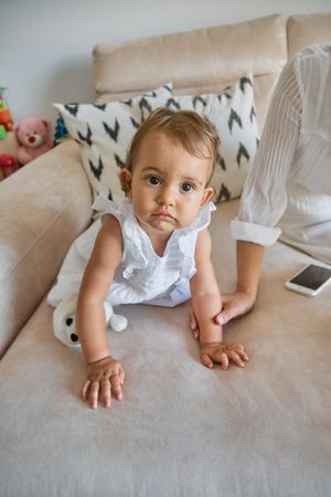 Happy baby girl sitting on sofa