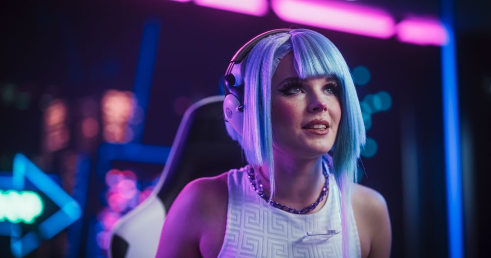 Stylish Streamer or Gamer with Blue Hair Chats with Internet Fans on Computer in Futuristic Cyber Technology Room.