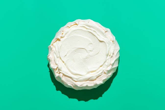 Pavlova cake in bright light, isolated on a green background